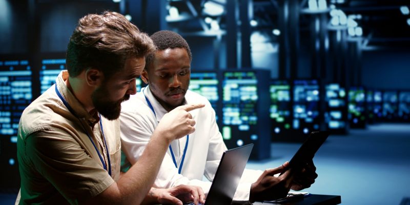 IT-Spezialisten führen Diagnosetests in einem Rechenzentrum durch – zuverlässige IT-Lösungen für Kommunen und den öffentlichen Dienst.