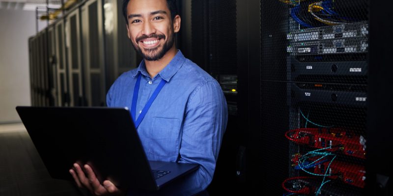 IT-Spezialist mit Laptop im Serverraum – Symbol für Künstliche Intelligenz und Automatisierung moderner IT-Prozesse.